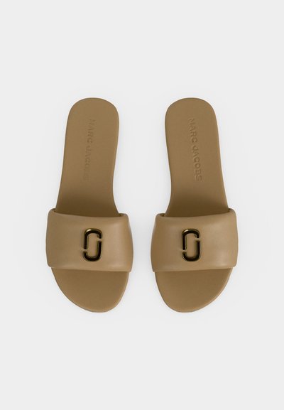 Ζευγάρι μπεζ σανδάλια τύπου slide με φαρδιές επενδυμένες λουρίδες, χρυσό διαπλεγμένο οβάλ λογότυπο και ανάγλυφο όνομα μάρκας στις εσωτερικές σόλες.