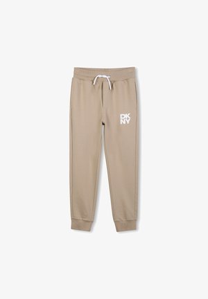 Beige sweatpants met elastische tailleband en trekkoord, voorzien van het witte "DKNY" logo op de linker dij, met cuffs aan de enkels en een gladde textuur.