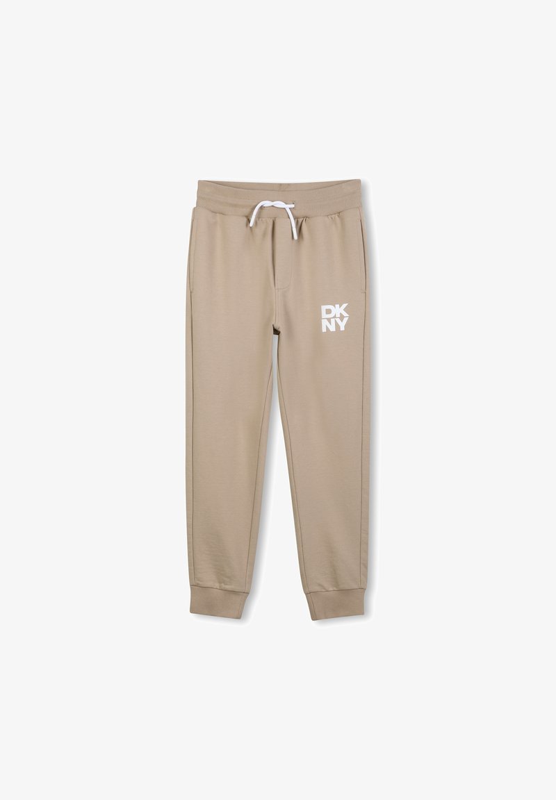 Beige sweatpants met elastische tailleband en trekkoord, voorzien van het witte "DKNY" logo op de linker dij, met cuffs aan de enkels en een gladde textuur.