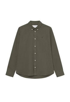 Tamsiai žalia marškiniai su mygtukų apykakle, ilgomis rankovėmis ir kreivu kraštu. Yra balti mygtukai ir mažas logotipas kairiajame krūtinės kampe.