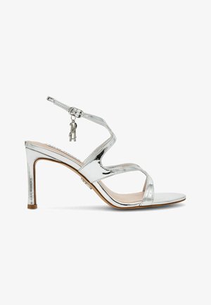 Sandalo con tacco alto e cinturino, in argento, con finitura liscia, cinturino alla caviglia e dettaglio decorativo con un piccolo portachiavi, con punta stretta e tacco a stiletto.