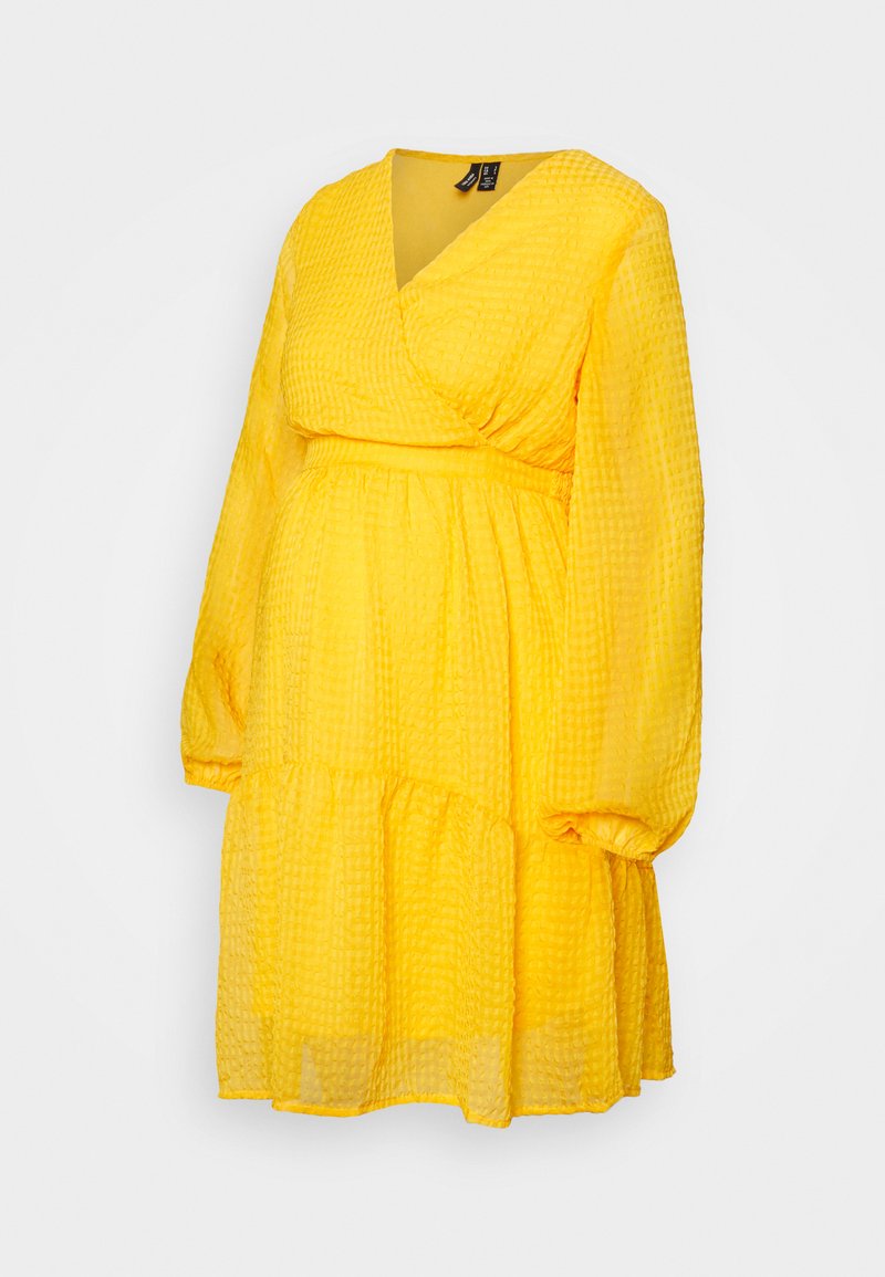 Vestido amarelo envolvente, feito de um tecido texturizado, apresenta um decote em V, mangas longas e um design de saia em camadas.
