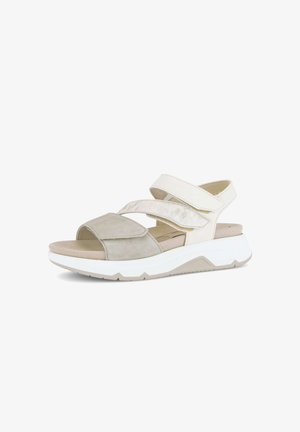 Beige en witte open-toe sandaal voor dames met verstelbare klittenbandsluitingen en dikke witte zool, afgebeeld op een witte achtergrond.