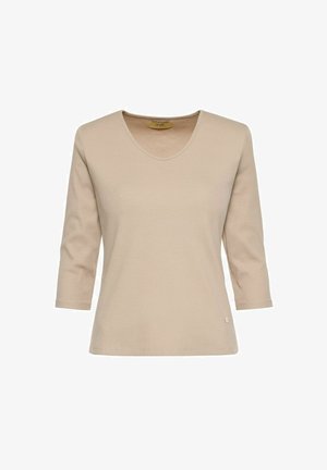 Beżowa bluzka z długim rękawem wykonana z prążkowanej tkaniny. Posiada dekolt w serek i małe logo na dolnym brzegu. Prosty krój i miękka tekstura.
