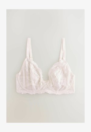Soutien-gorge en dentelle blanche avec des motifs floraux, des bonnets transparents et des bords festonnés. Présente des bretelles en satin réglables et une bande douce sous la poitrine.