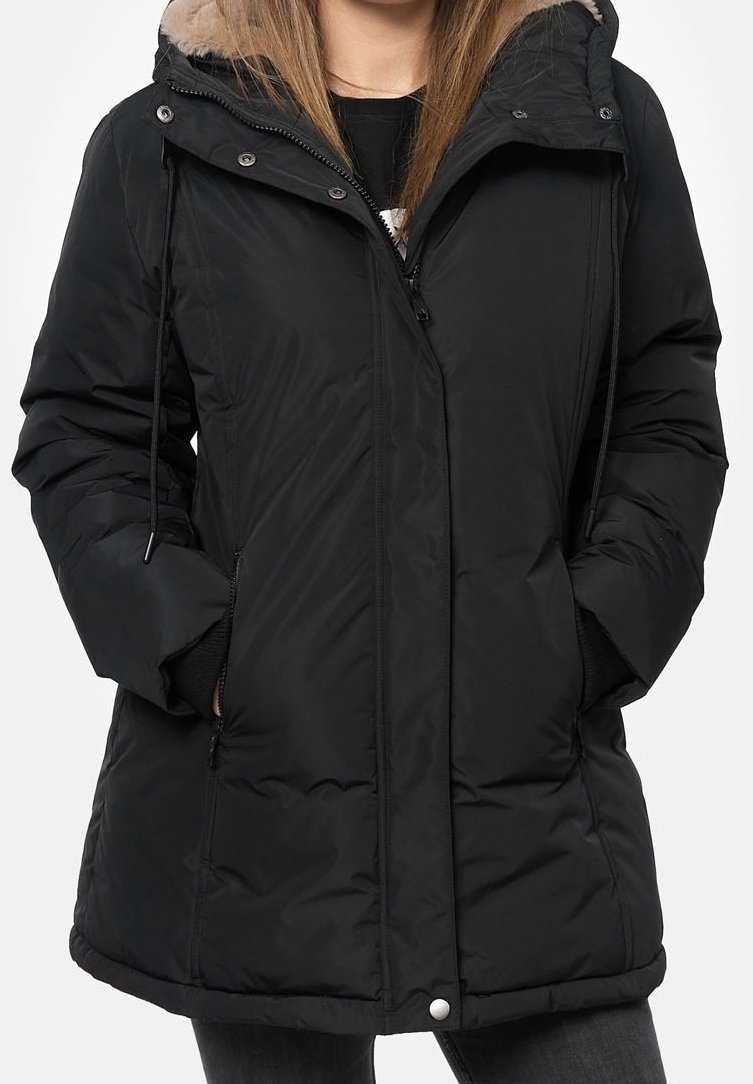 Svart puffjacka med foder i päls på huvan, frontdragkedja, sidofickor och justerbara dragskor. Har en lång, lätt böjd nederkant.