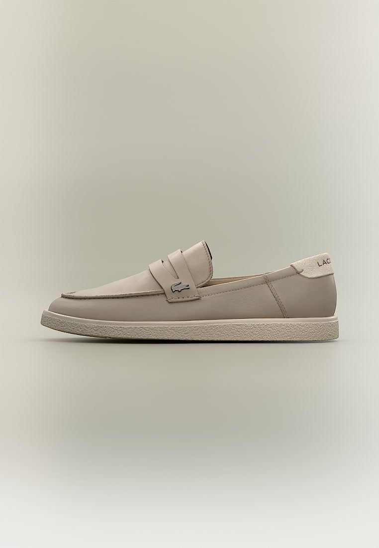 Бежови кожени обувки тип „слip-on“ с малко метално лого крокодил на каишката и текстурирана гумена подметка.