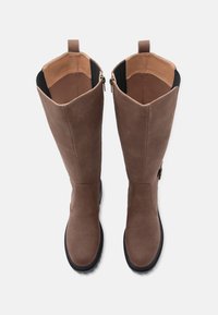 Braune Stiefel bis zum Knie aus Kunstleder mit einer glatten Oberfläche, elastischen Seiteneinsätzen und einem Reißverschluss. Sie haben eine runde Spitze und eine strukturierte Sohle.