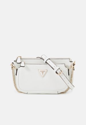 White Guess crossbody bag with gold chain strap, adjustable leather strap, front zipper pocket, and triangular logo plaque.