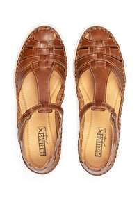 Sandalias de cuero marrón con diseño trenzado, lados abiertos, correa ajustable y plantilla acolchada. Suela ligera con un acabado ligeramente texturizado.