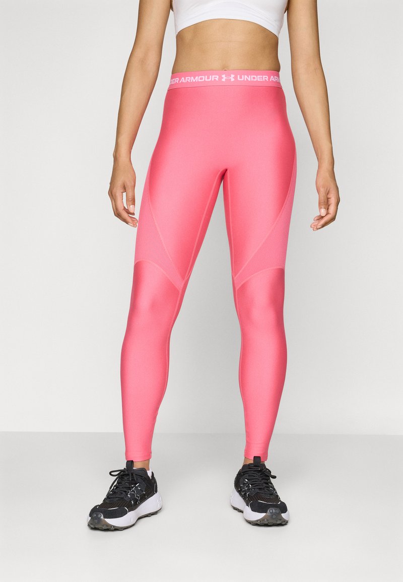 Rosa atletiske leggings laget av elastisk stoff. Funksjoner inkluderer en tettsittende design, nettinginnsatser og et bredt midjebånd med merkevare.