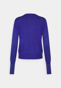 Fioletowy sweter wykonany na drutach z okrągłym dekoltem, długimi rękawami oraz prążkowanymi mankietami i obrzeżem. Gładka tekstura i lekki materiał.