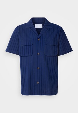 Camisa de manga corta azul marino con un patrón de rayas texturizado, dos bolsillos en el pecho y botones marrones en la parte delantera y en el cuello.