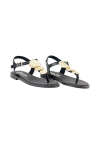 Sandalias planas negras con acentos texturizados dorados que cuentan con tres formas decorativas, correa ajustable en el tobillo y una suela acolchada.