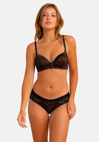 Ensemble de lingerie en dentelle comprenant un soutien-gorge noir avec des motifs floraux orange et un string noir assorti. Tissu doux avec des bretelles réglables.
