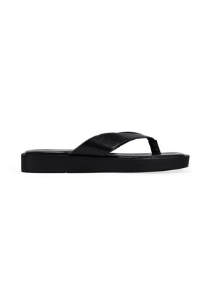 Sandalia de flip-flop negra de cuero con amplia correa cruzada y suela plana sobre fondo blanco liso.
