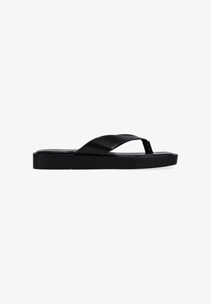 Sandalia de flip-flop negra de cuero con amplia correa cruzada y suela plana sobre fondo blanco liso.