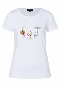 Camiseta blanca de manga corta con tres ilustraciones de zapatos de mujer en estampados de animal print, rayas y lunares, sobre el texto "vístete para la vida."