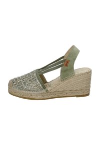 Sandalo con zeppa espadrille verde, con tomaia intrecciata, cinturini elastici e tacco coperto di juta. Presenta una superficie testurizzata e una suola neutra.