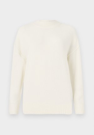 Suéter blanco de punto con un cuello y puños acanalados. Presenta un corte holgado y una textura suave, ideal para superponer en climas más frescos.