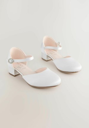 Białe satynowe buty na kostkę z kwadratowym noskiem i niskim obcasem w kształcie bloku. Pasek ma okrągłą, srebrną klamrę.