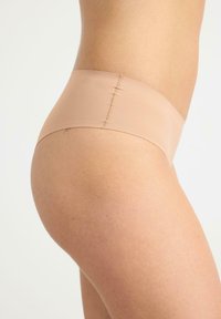 Beige sömlös hipsterunderkläder med en slät textur och minimal sömnad, med låg midja och bekväm passform.