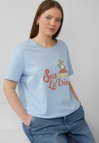 Lichtblauwe T-shirt met korte mouwen, voorzien van een kleurrijke tekst "Sea La Vie" en een palmbomenontwerp. Gemaakt van zachte katoen.