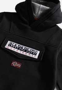 Sweat à capuche noir avec poche avant à rabat ornée d'un écusson blanc "Napapijri geographic" et un petit drapeau norvégien sous la poche.