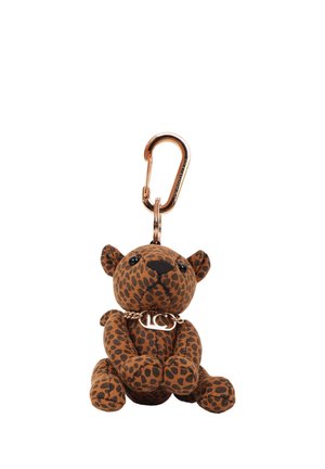 Pequeño llavero de peluche con forma de leopardo con manchas marrones y negras, ojos negros y un collar de cadena dorado unido a un mosquetón dorado.