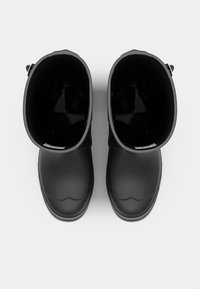 Bottes en caoutchouc noires avec une texture lisse, un bout rond et une doublure intérieure. Elles possèdent un design pliable et une apparence minimaliste.