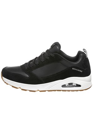Sneaker noir avec un mélange de matériaux lisses et texturés. Comprend une semelle intermédiaire blanche, une semelle extérieure en caoutchouc beige et des détails de coussin d'air.