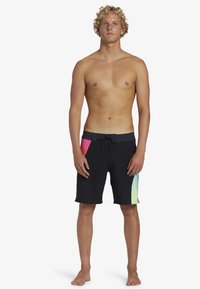 Zwarte boardshorts met een grijze tailleband, voorzien van roze en groene accenten aan de zijkant. Gemaakt van lichtgewicht, sneldrogend materiaal.