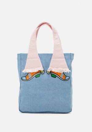 Sac fourre-tout bleu avec des anses en tissu rose ressemblant à des jambes portant des bottes de cow-boy colorées avec des éperons.
