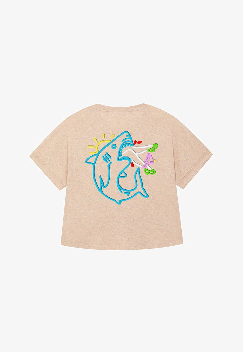 Béžové tričko s voľným strihom. Má modro vyšívaného žraloka so slnkom, ktorý drží farebné predmety. Krátke rukávy a mäkká textúra.