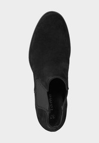 Zapato negro de ante tipo slip-on con paneles laterales elásticos y punta redondeada. La plantilla interna presenta una marca visible. Textura suave en toda su superficie.