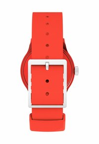 Montre en silicone rouge avec une texture lisse, boucle rectangulaire en argent, boîtier rond et un design minimaliste avec des trous de sangle ajustables.