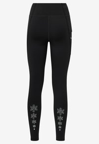 Zwarte leggings met een hoge tailleband, voorzien van een zijzak en witte geometrische patronen langs de onderbenen. Gemaakt van rekbaar materiaal.