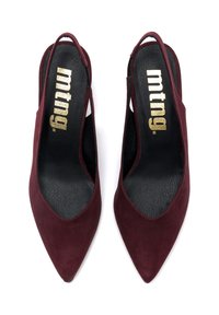 Décolleté in suede bordeaux con tacco a slingback e punta affusolata, dotate di un'inserto nera e il logo dorato "mtng." per il branding.