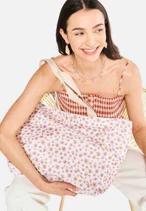 Große Stofftasche mit einem pastellrosa Hintergrund und mehrfarbigen, abstrakten Flecken. Cremefarbener Tragegurt und weiche Textur. Leichtes Design.