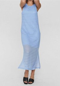 Abito maxi lavorato a maglia blu chiaro con un design senza maniche, caratterizzato da strisce orizzontali e uno spacco laterale; abbinato a sandali neri con tacco a blocco open-toe.