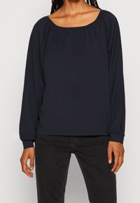 Navy long-sleeve top with a square neckline, gathered detailing around the neck, and elasticated cuffs, made from soft, stretchy fabric.