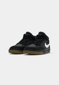 Svarte høye sneakers laget av lær og semsket skinn. Har en hvit swoosh, perforerte detaljer på tåboksen, og en såle av gummigummi.