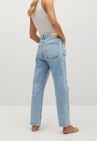 Vaaleansiniset farkut rentolla istuvuudella, korkealla vyötäröllä, edessä revityillä yksityiskohdilla ja klassisella viiden taskun mallilla.