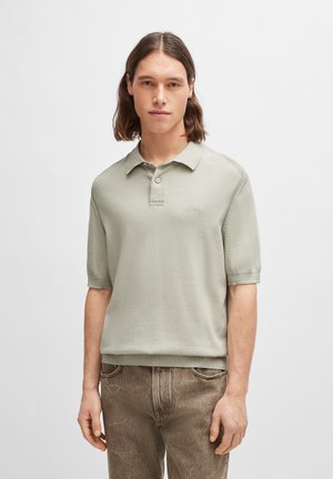 Gebreide polo met korte mouwen in lichtgroene katoen, met een klassieke kraag, een knoopsluiting met twee knopen en een subtiele logo-broderie op de borst.