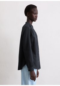 Czarna koszula na guziki z kołnierzykiem typu mandarynka, długimi rękawami i lekko luźnym krojem. Wykonana z gładkiej tkaniny, charakteryzuje się eleganckim designem.