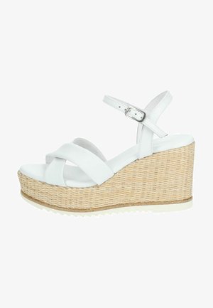 Sandali wedge bianchi con platform in juta intrecciato, dotati di fasce incrociate e di una cinghia per la caviglia regolabile. Materiale in pelle liscia.