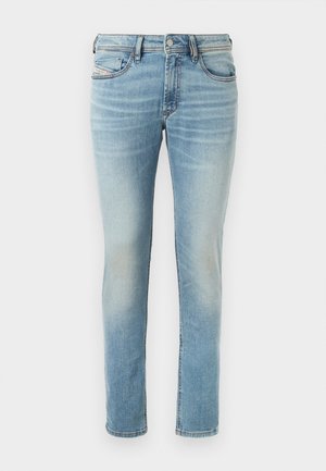 Hellblaue Denim-Jeans mit tailliertem Schnitt, fünf Taschen, subtilen Auswaschungen, mit Knopfverschluss und Gürtelschlaufen.