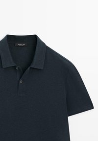 Polo bleu marine foncé à manches courtes avec une patte de boutonnage à deux boutons et un col plié. Étiquette indiquant Massimo Dutti.