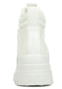 Weiße High-Top-Sneaker mit einem strukturierten Obermaterial, dicker Sohle und auffälligem Logo an der Ferse. Minimalistisches Design mit glatter Oberfläche.