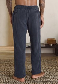 Navy corduroy pajama pants with a relaxed fit, elastic waistband, and textured surface. Features straight legs and no visible pockets.